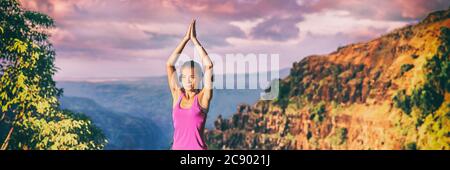 Ritiro yoga in Kauai bandiera panoramica natura. Ragazza asiatica che pratica la meditazione in spazi aperti al tramonto seduto con le mani di preghiera in testa per la posa dell'albero Foto Stock