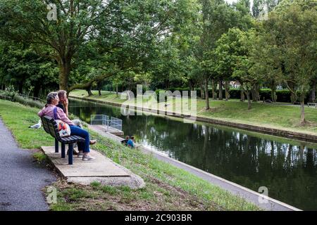 Canale militare di Hythe. Un uomo e una donna si siedono su una panchina e si rilassano a lato dell'acqua. Foto Stock