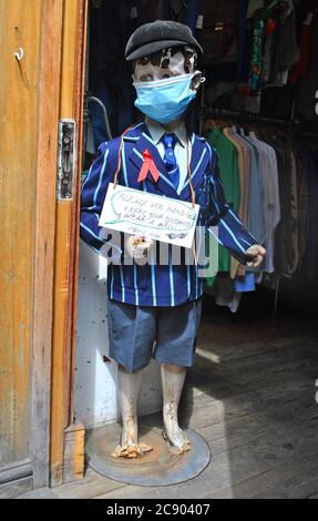 MASCHERA CHE INDOSSA EX CHARITY MANNEQUIN SI TROVA ALL'INGRESSO DI UN NEGOZIO DI CORSIA DI MATTONI, LONDRA, IL GIORNO IN CUI LA MASCHERA INDOSSATA NEI NEGOZI È FATTO MANDATARIO. Foto Stock