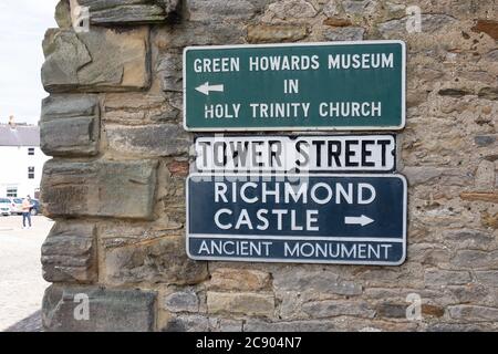 Cartelli segnaletici su Wall, Tower Street, Richmond, North Yorkshire, Inghilterra, Regno Unito Foto Stock