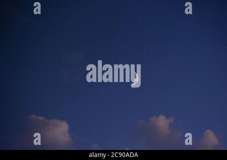 Paesaggio notturno, cielo stellato blu scuro, vista della luna luminosa (Crescent) e alcune piccole nuvole. Foto su un obiettivo a fuoco lungo con strati applicati Foto Stock