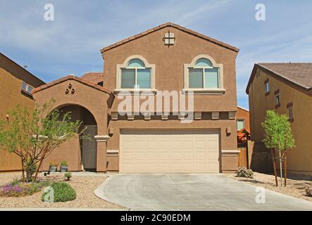 Nuova casa di stucco a due piani, marrone e beige a Tucson, Arizona, Stati Uniti d'America, con un bel cielo blu e un paesaggio. Foto Stock