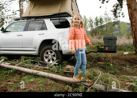 USA, Utah, Uninta Wasatch cache National Forest, ragazza (6-7) in piedi sul registro in auto Foto Stock