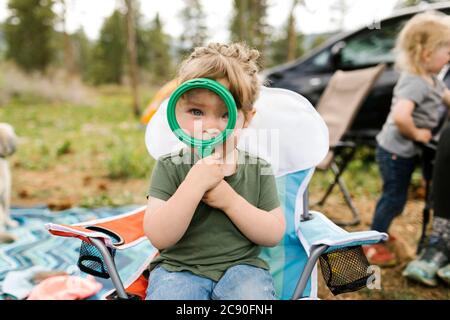 USA, Utah, Uninta Wasatch cache National Forest, ragazza (2-3) guardando attraverso la lente di ingrandimento Foto Stock