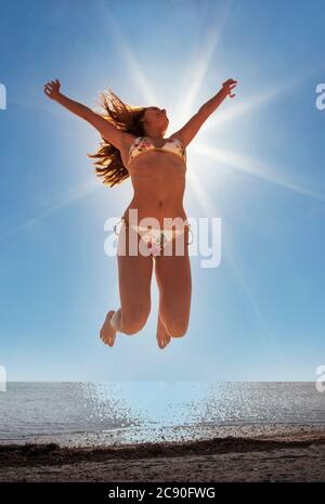 USA, Florida, Miami Beach, giovane donna che salta sulla spiaggia Foto Stock