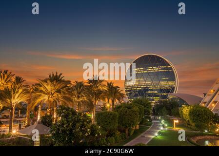 Emirati Arabi Uniti, Abu Dhabi, sede centrale di Aldar Properties al tramonto Foto Stock