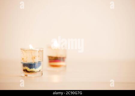 Gel candele in piccolo vetro trasparente con fiamma posta sul tavolo. Foto Stock