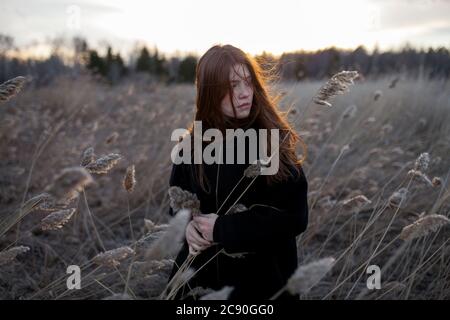 Russia, Omsk, Ritratto di adolescente (16-17) ragazza in erba alta Foto Stock