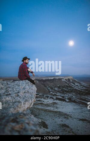 Ucraina, Crimea, Hiker seduto sul bordo di ripida scogliera vicino a White Mountain Foto Stock
