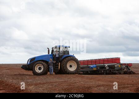 paese lavoratore ragazza sul campo sperando su un grande industria di camion Foto Stock