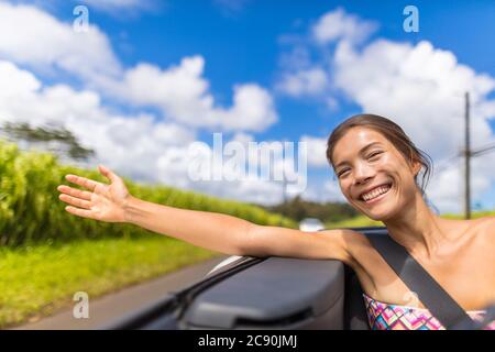 Auto strada viaggio donna libertà con la mano fluttuante nel vento. Ragazza asiatica seduta in automobile convertibile spensierata godendo la vacanza di viaggio della strada con il braccio Foto Stock