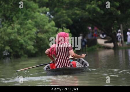 Pechino, Cina. 28 luglio 2020. Una ragazza fila una barca in una zona allagata a Munshiganj alla periferia di Dhaka, Bangladesh, il 27 luglio 2020. Quasi la metà del Bangladesh è rimasta in piena alluvione lunedì con un numero di vittime. Secondo il rapporto sulla situazione delle inondazioni quotidiano del centro di coordinamento per la risposta alle catastrofi del paese, le inondazioni hanno ucciso 119 persone in 21 (su 64) distretti dal giugno 30. Credit: Xinhua/Alamy Live News Foto Stock