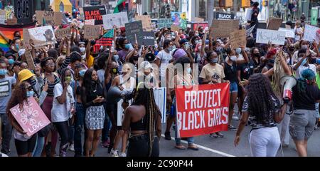 Black Womens/Womxn marzo Black Lives Matter protesta - New York City, proteggere Black Girl Banner conduce marcia in strada Foto Stock