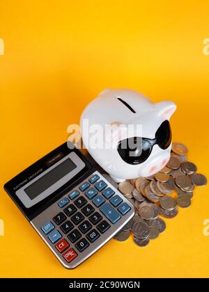 conservazione del capitale in una crisi economica calcolatrice monete di fondo giallo Foto Stock