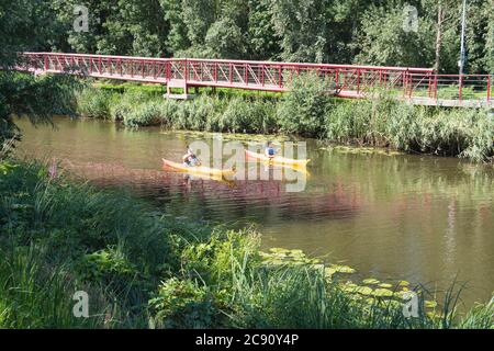 Lokeren, Belgio, 13 luglio 2020, l'uomo e la donna stanno navigando sulla Durme in una canoa gialla Foto Stock