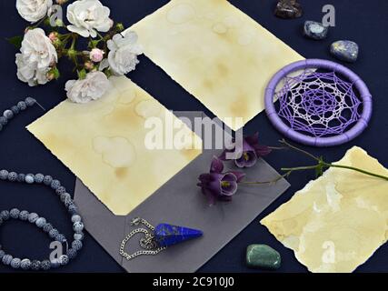 Fogli di carta vuoti con busta, oggetti magici, cristallo e fiore sul tavolo. Sfondo mistico e romantico con spazio per la copia e bianco, romantico vintage Foto Stock