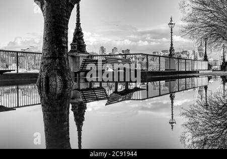 Londra si è riflessa in una pozza sulla riva sud in questa foto in bianco e nero scattata dopo una pioggia intensa Foto Stock