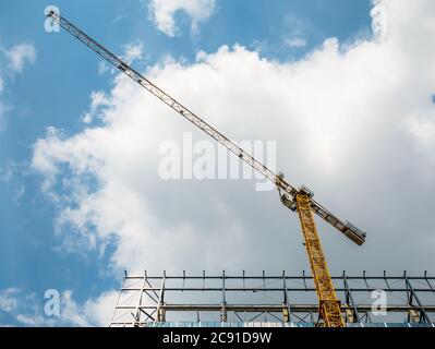 Gru di costruzione o gru di costruzione su un cantiere contro cielo blu Foto Stock