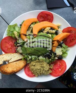 colazione con insalata fresca, pane tostato servito con pasta, papaya, pomodoro, avocado. Foto Stock