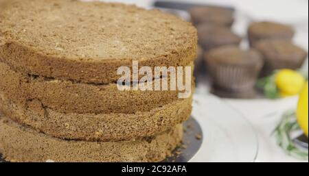 Passo dopo passo. Ragazza che monta una torta al cioccolato con crema di burro brillante e colorata Foto Stock