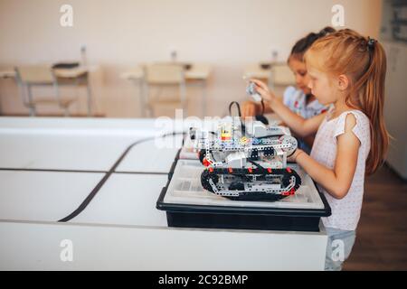 Due studentesse studiano in una classe robotica, assemblano un costruttore di robot Foto Stock