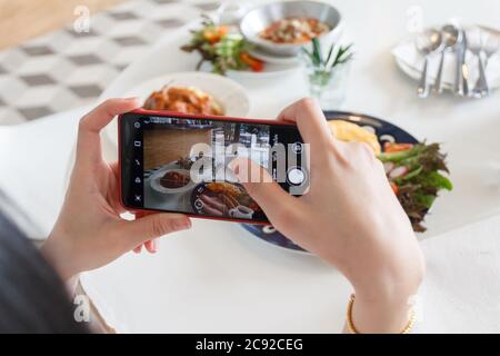 12 luglio 2020 - Khaoyai Thailandia : mani con il telefono primo piano immagini della colazione. Foto Stock