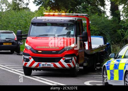 Un carrello di recupero che recupera un veicolo dopo essere stato coinvolto in una collisione sulla A642 Wakefield Road a Swillington Foto Stock