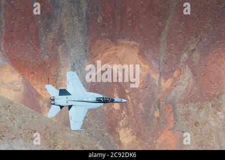 US Navy F/A-18F Super Hornet volare a basso livello e ad alta velocità attraverso Rainbow Canyon, California, USA. Foto Stock