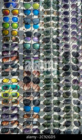 molti occhiali da sole nella vetrina del negozio. stand con campioni sulla strada in una giornata estiva. Foto Stock