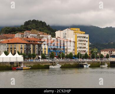 Lungomare delle Asturie Ribadesella con barche ormeggiate da pesca in un pomeriggio estivo nuvoloso Foto Stock