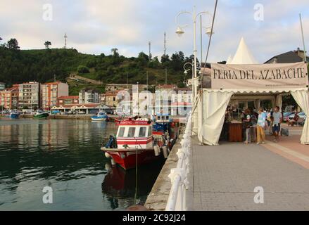 Luce della sera con riflessi in acque calme con barche da pesca ormeggiate a Ribadesella Asturias Spagna Foto Stock