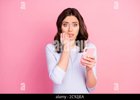 Foto di bella signora terrorizzata tenere telefono tempo di quarantena letto news corona virus infezione diffusione morso dita paura indossare casual camicia bianca Foto Stock