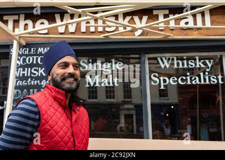 Edimburgo, Scozia, Regno Unito. 28 luglio 2020. Affari e turismo tornano lentamente ai negozi e alle strade del centro di Edimburgo. MR Bindi Landa fuori dal negozio Whisky Trail, in fase di ristrutturazione, sul Royal Mile, uno dei numerosi negozi di orientamento turistico che possiede. I suoi negozi sono in fase di riapertura per soddisfare un numero crescente di turisti che ritornano nella Città Vecchia. Iain Masterton/Alamy Live News Foto Stock