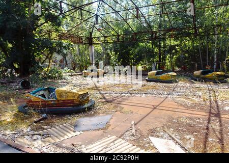 Abbandonato giro in auto di divertimenti nel parco delle attrazioni della città fantasma di Pripyat nella zona di esclusione di Chernobyl, catastrofe nucleare Foto Stock