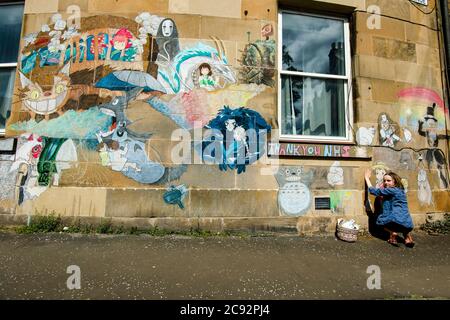 Molly lavora sulla loro arte murale in gesso sul viale Mentone di Portobello. La Scozia è in una nona settimana di blocco a causa dell'epidemia di covid-19. Credito: Euan Cherry Foto Stock