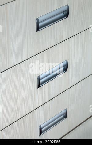 armadietti di dresser primo piano, struttura di un albero di colore bianco con manici grigi. Foto Stock