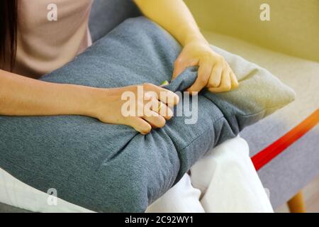 Donna asiatica paziente pizzico a cuscino grigio tra lo psicologo parlare con la sua malattia in Clinic.The paziente paura dopo lungo soggiorno a casa in virus out b Foto Stock