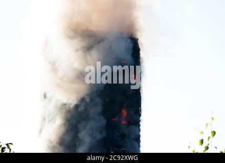 Il fumo sorge dal fuoco alla Grenfell Tower, un blocco di appartamenti a 24 piani parte della Lancaster West Estate a North Kensington, Londra, Regno Unito. Il fuoco è stato avviato la mattina presto da un frigorifero-congelatore difettoso al quarto piano. Si diffonde rapidamente sull'esterno dell'edificio, attraverso il rivestimento esterno e l'isolamento. L'incendio causò 72 morti, comprese quelle di due vittime che poi morirono in ospedale. Oltre 70 persone sono rimaste ferite e 223 sono fuggite. È stato il più letale incendio strutturale del Regno Unito dal 1988 e il peggiore incendio residenziale britannico dalla seconda guerra mondiale Foto Stock