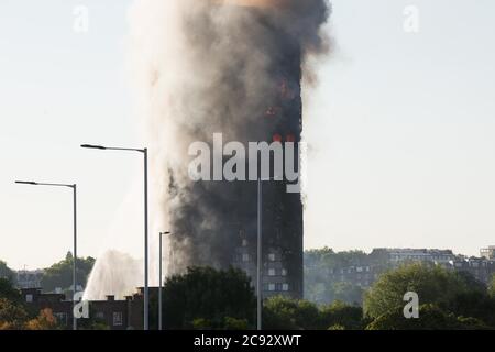 Il fumo sorge dal fuoco alla Grenfell Tower, un blocco di appartamenti a 24 piani parte della Lancaster West Estate a North Kensington, Londra, Regno Unito. Il fuoco è stato avviato la mattina presto da un frigorifero-congelatore difettoso al quarto piano. Si diffonde rapidamente sull'esterno dell'edificio, attraverso il rivestimento esterno e l'isolamento. L'incendio causò 72 morti, comprese quelle di due vittime che poi morirono in ospedale. Oltre 70 persone sono rimaste ferite e 223 sono fuggite. È stato il più letale incendio strutturale del Regno Unito dal 1988 e il peggiore incendio residenziale britannico dalla seconda guerra mondiale Foto Stock