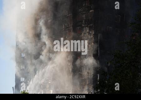 Il fumo sorge dal fuoco alla Grenfell Tower, un blocco di appartamenti a 24 piani parte della Lancaster West Estate a North Kensington, Londra, Regno Unito. Il fuoco è stato avviato la mattina presto da un frigorifero-congelatore difettoso al quarto piano. Si diffonde rapidamente sull'esterno dell'edificio, attraverso il rivestimento esterno e l'isolamento. L'incendio causò 72 morti, comprese quelle di due vittime che poi morirono in ospedale. Oltre 70 persone sono rimaste ferite e 223 sono fuggite. È stato il più letale incendio strutturale del Regno Unito dal 1988 e il peggiore incendio residenziale britannico dalla seconda guerra mondiale Foto Stock