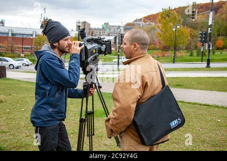 MONTREAL, CANADA - Ottobre 16, 2010: Montreal, Quebec / Canada - Ottobre 16 2010: Cameraman utilizzando la fotocamera Panasonic con montaggio a spalla su un treppiede accanto a un SH Foto Stock
