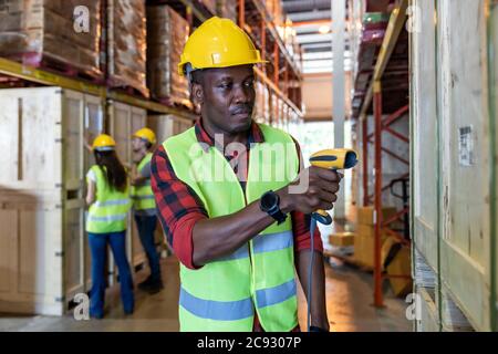 Ritratto di un lavoratore africano di magazzino nero tenere scanner a mano per fare magazzino di lavoro di inventario nel magazzino di distribuzione. Tracciabilità FIFO inventario LIFO ju Foto Stock