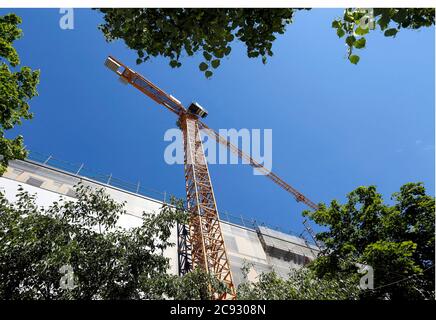 Vista della gru con la costruzione e gli alberi a Vienna, Austria Foto Stock