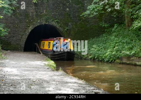 Una stretta barca emerge dal tunnel Chirk sul Llangollen Canal Chirk Denbighshire Galles Regno Unito Foto Stock