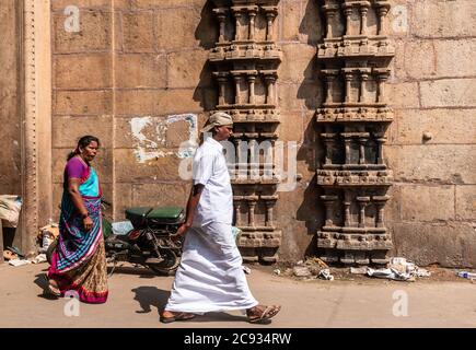 Trichy, Tamil Nadu, India - Febbraio 2020: Pellegrini che camminano oltre l'antica pietra sulle pareti del tempio Sri Ranganathaswamy a Srirangam. Foto Stock