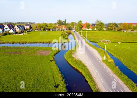 In aereo da un tipico paesaggio olandese: Prati pianeggianti, canali e tradizionali case in legno nella campagna olandese Foto Stock