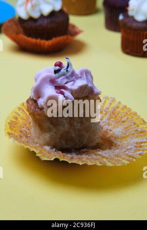 Primo piano verticale di un cupcake con crema rosa Foto Stock