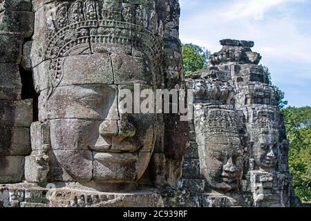 12 ° secolo facce di pietra a Angkor Thom / Nokor Thom, capitale dell'Impero Khmer, Siem Reap, Cambogia Foto Stock