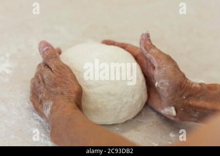 mani da donna impastate per preparare l'impasto per gnocchi. Foto Stock