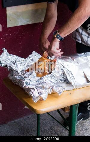 Maialino alla griglia / suzione, con la pelle ancora su di esso avvolto in lamina di alluminio. Foto Stock